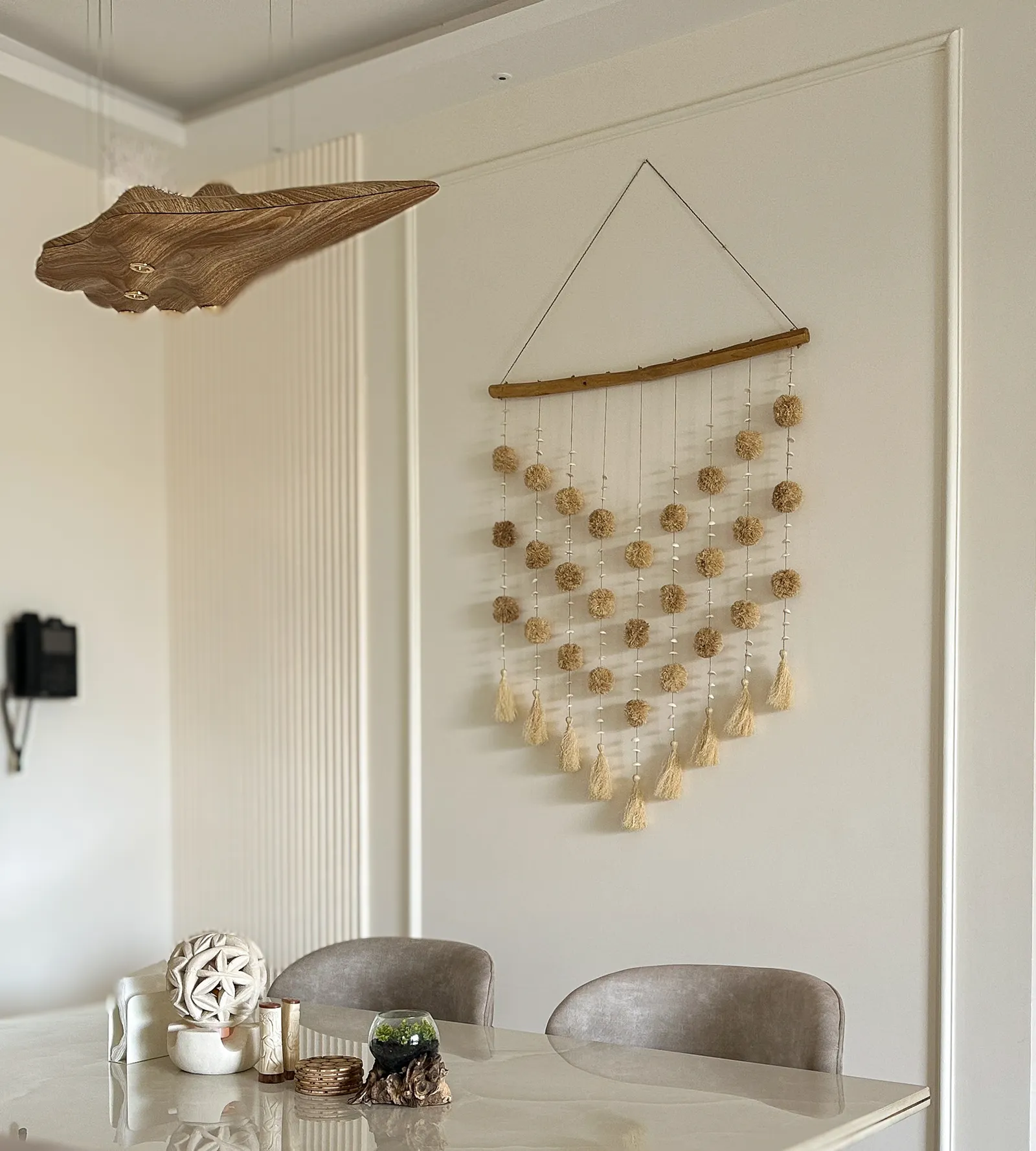 Dining wall with macramé hanging and timber leaf sculpture — Somani's Residence